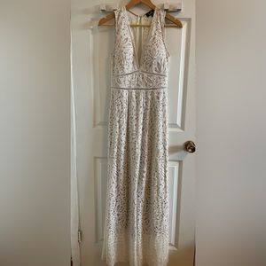 Ivory lace jumpsuit with nude underlay.